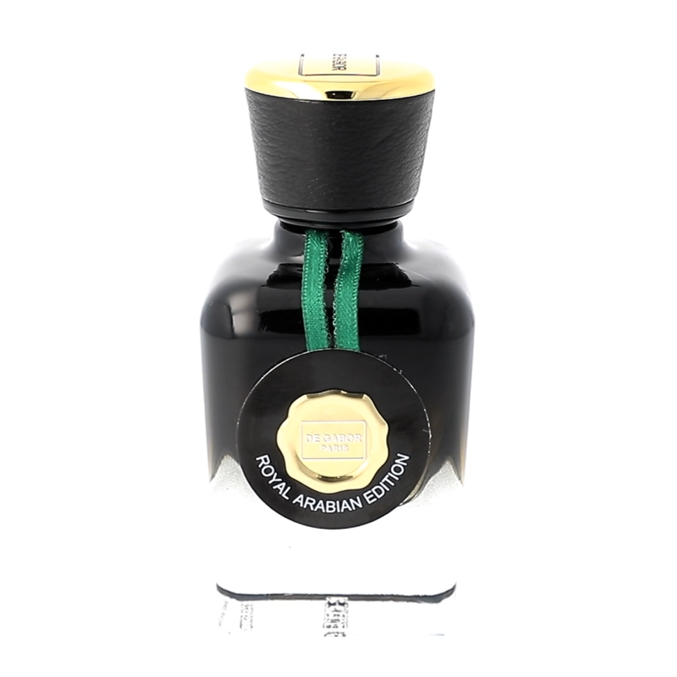 Perfume bottle with black cap and green ribbon on a white background