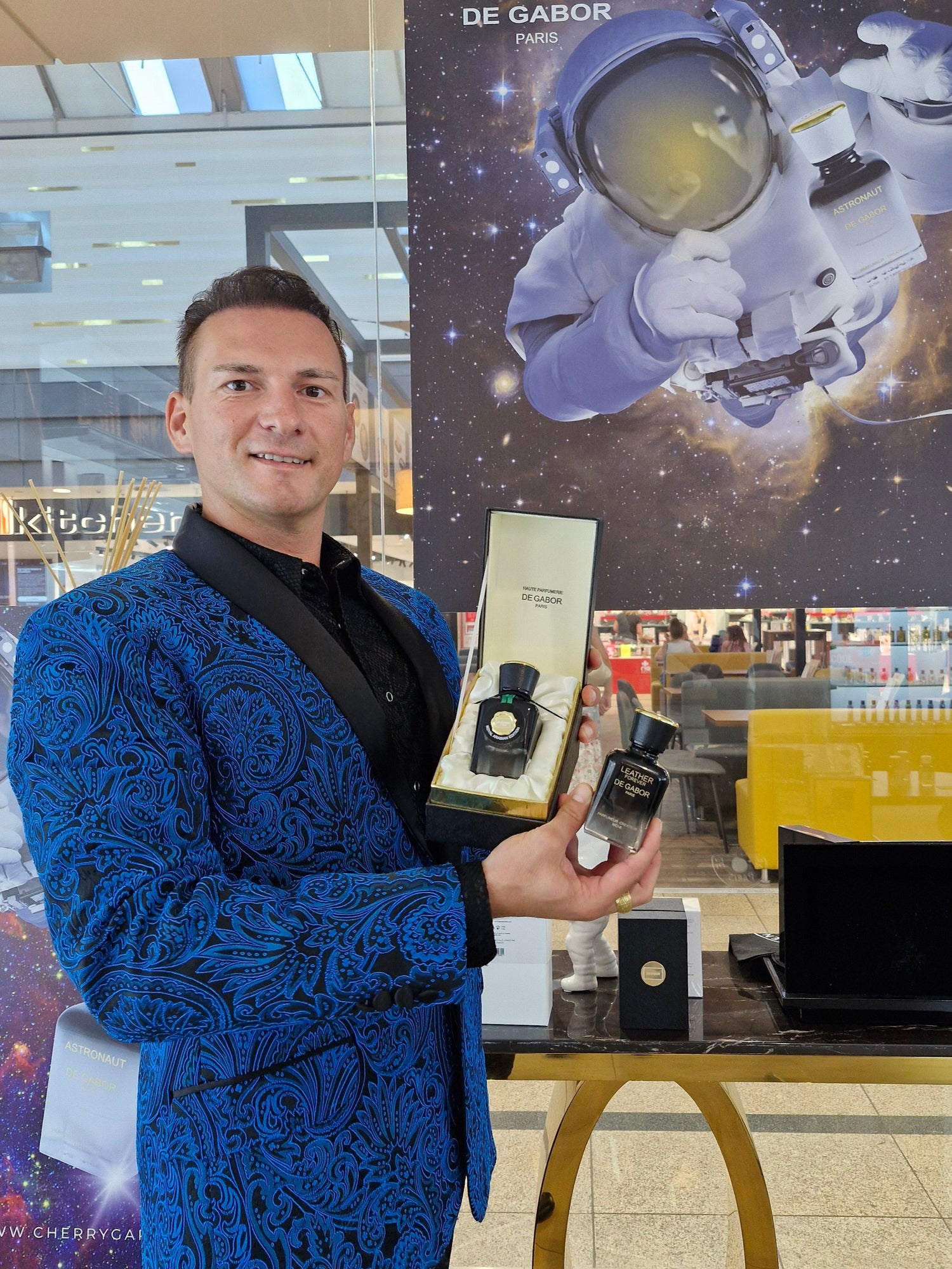 Person holding a product with a space-themed poster in the background